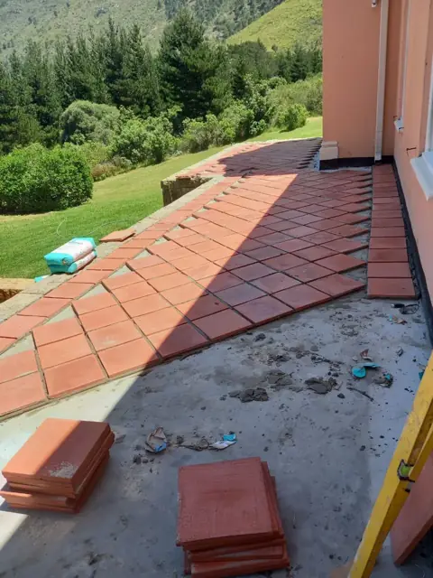 Terracotta paving slabs being laid on a patio