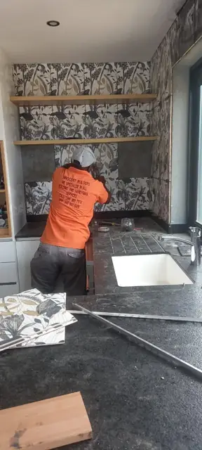 Tiler fitting a patterned kitchen splashback
