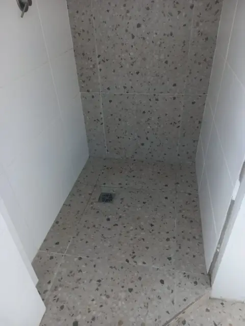 Terrazzo-look tiled shower floor and wall tiles