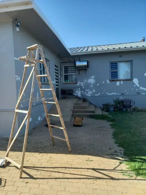 Ladder against a house, exterior painting prep underway