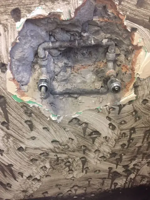 Chased-out wall showing concealed mixer pipework