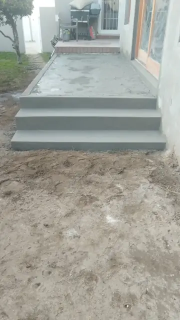 New concrete steps and screeded patio at a rear entrance; alt plastering