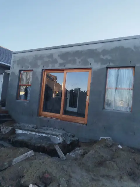 Newly plastered house extension exterior with timber windows
