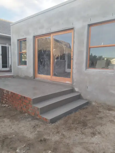 Plastered extension with sliding door and new brick steps