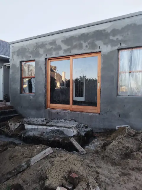 Plastered wall with window opening and excavation in front