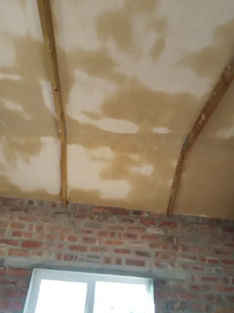 Skimmed vaulted ceiling above exposed brick walls