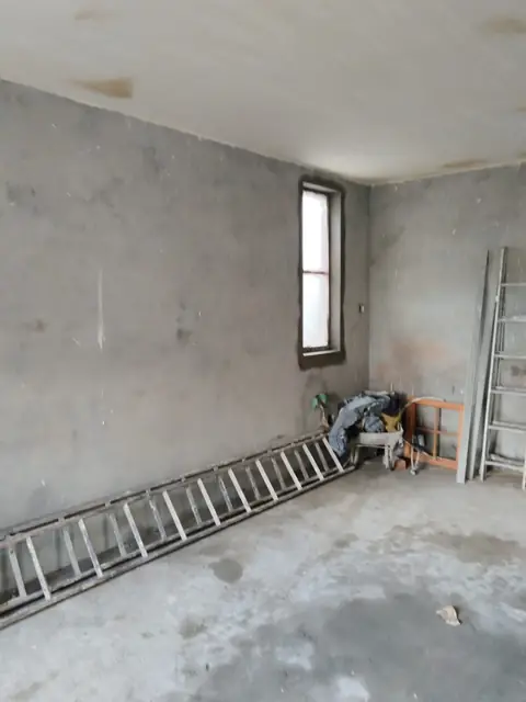 Interior room with grey plastered walls and ladders
