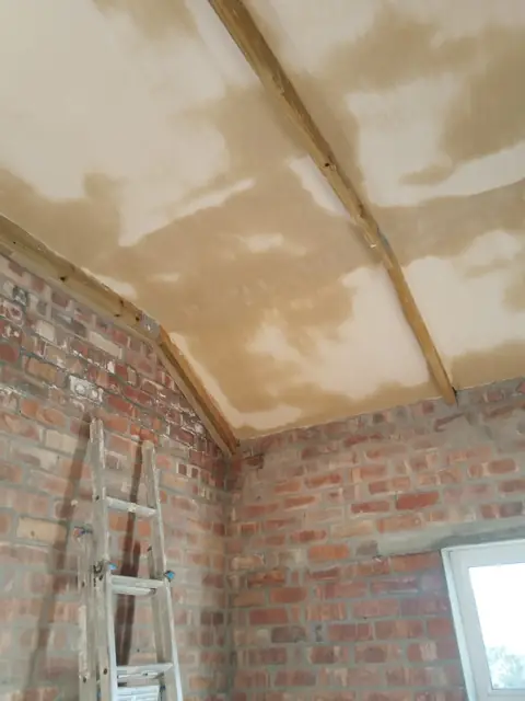 Vaulted skimmed ceiling over brick walls with ladder