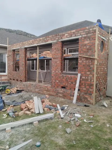 Brick extension with window openings and scaffolding on site