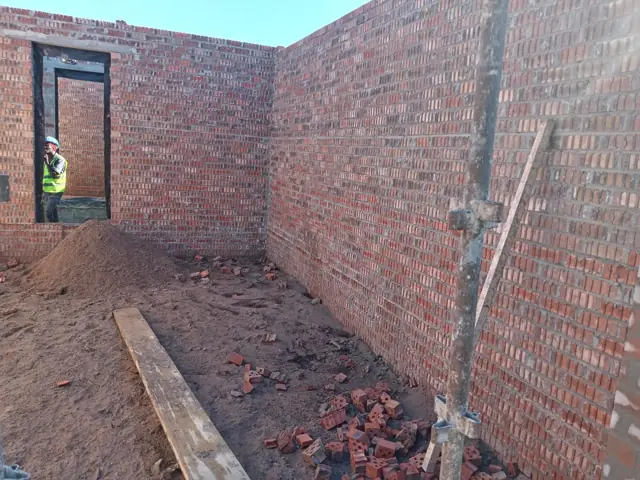 Interior brick walls of an extension with worker in doorway