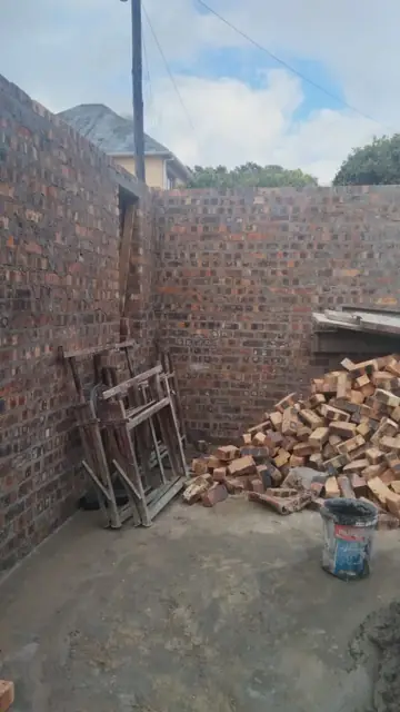 New brick wall corner with stacked bricks on site