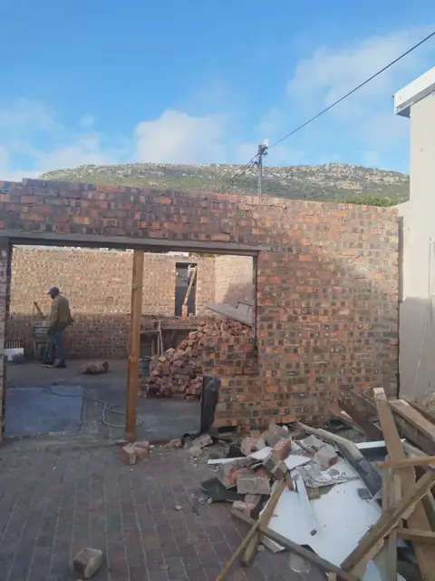 Brick garage with lintel over the opening, worker on site