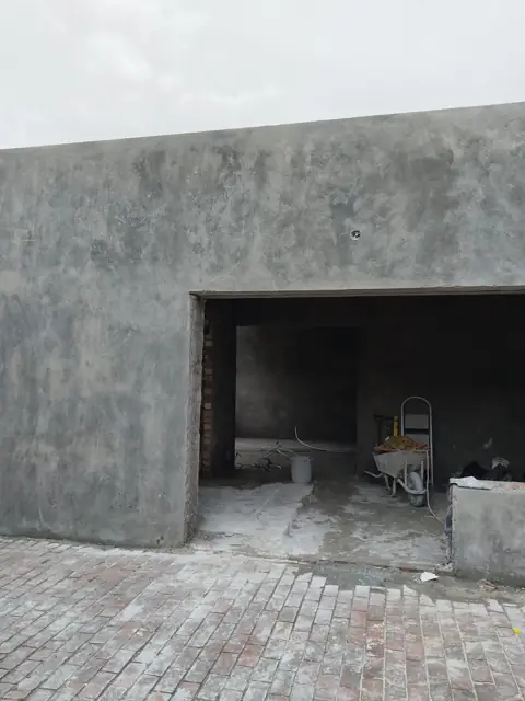 Freshly plastered garage exterior with vehicle opening