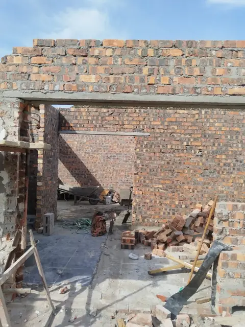 Brick gable wall with opening and scaffolding