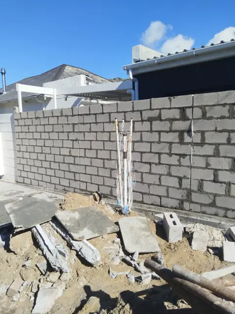 Block boundary wall with pillar under construction
