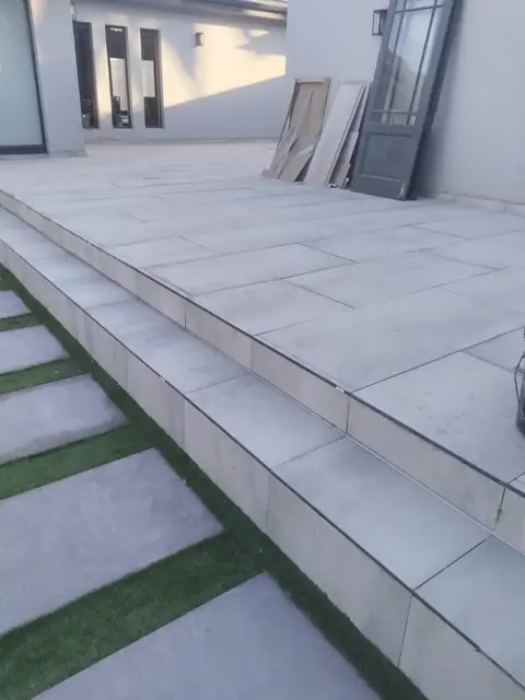 Large-format tiled patio and steps at a house exterior; alt flooring