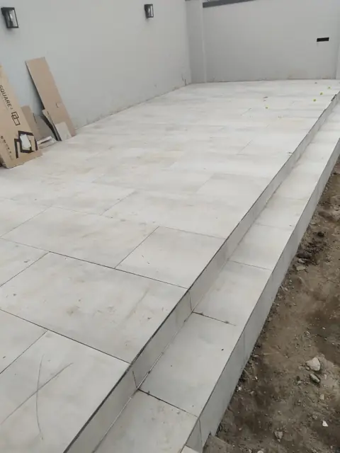 Long tiled outdoor terrace with step, before finishing; alt flooring