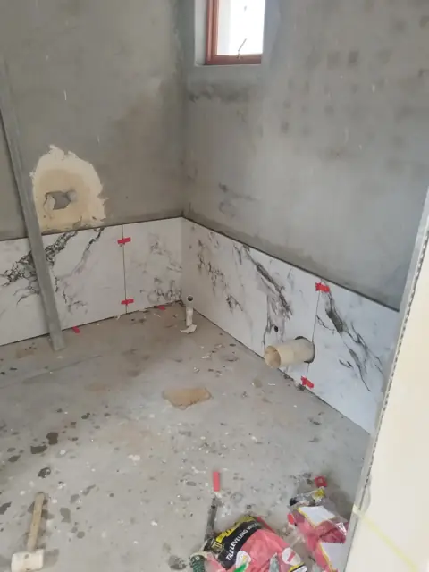Bathroom with marble-look tiles part-way up the walls