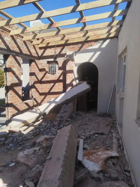 Open timber roof rafters over a brick building during re-roofing
