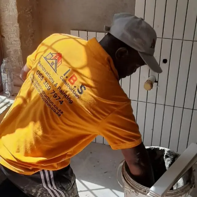 IBS tiler fixing vertical stack tiles to a wall