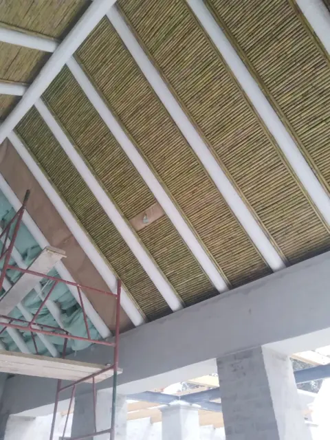 Reed ceiling panels under exposed painted roof beams