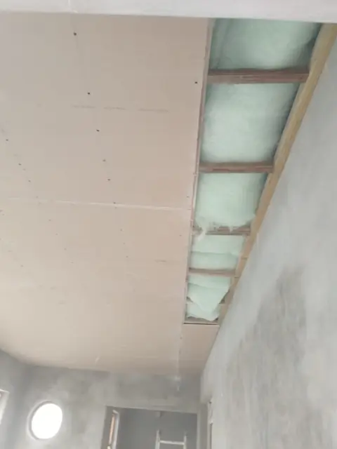 Plasterboard ceiling partially installed with insulation visible; alt skimming