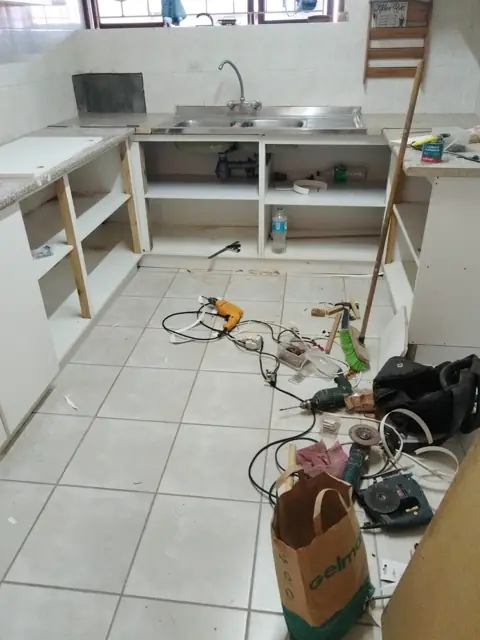 Kitchen cabinet carcasses under construction on a tiled floor