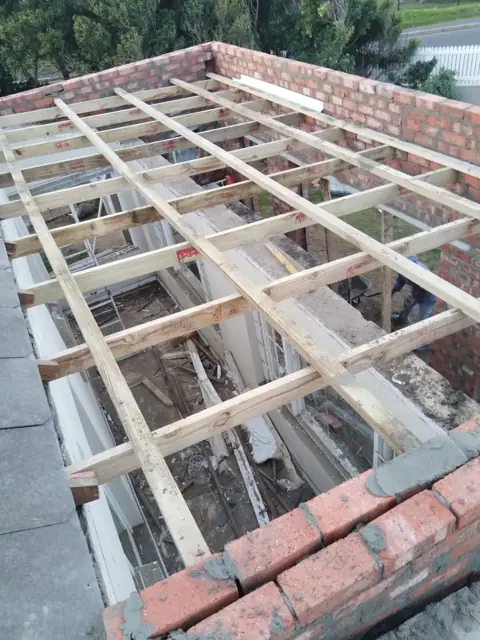 New timber roof joists laid over brick walls