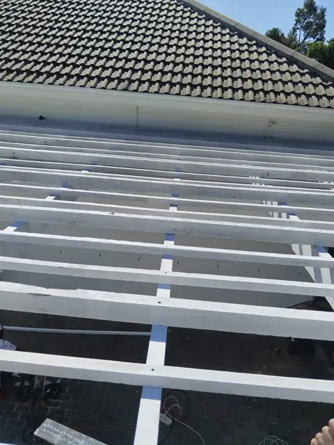 White roof battens over waterproofing membrane, tiled roof behind