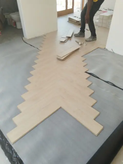 Herringbone laminate floor installation in progress