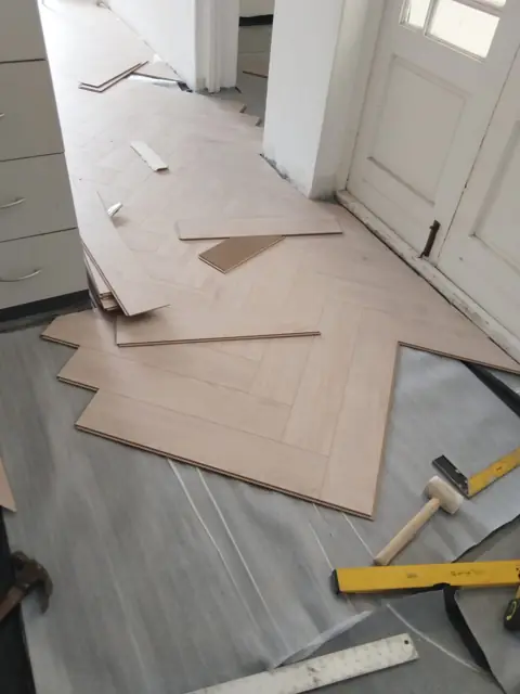 Laying herringbone pattern wood flooring at doorway