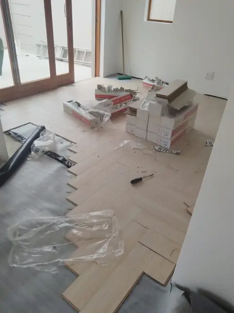 Herringbone floor installation across open-plan room