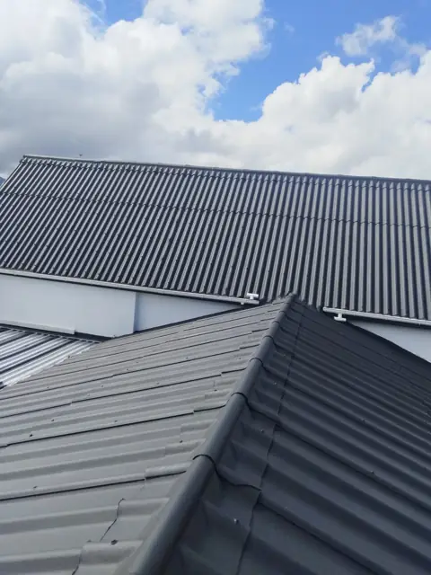 Recoated metal roof against sky
