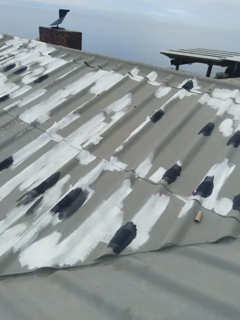 Roof tiles spot-primed before final coat