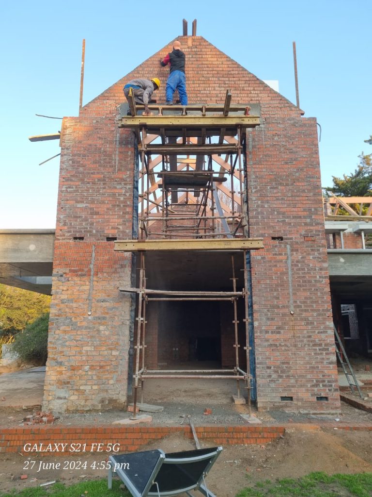 Double-storey brick house under construction with scaffolding — small construction companies in cape town