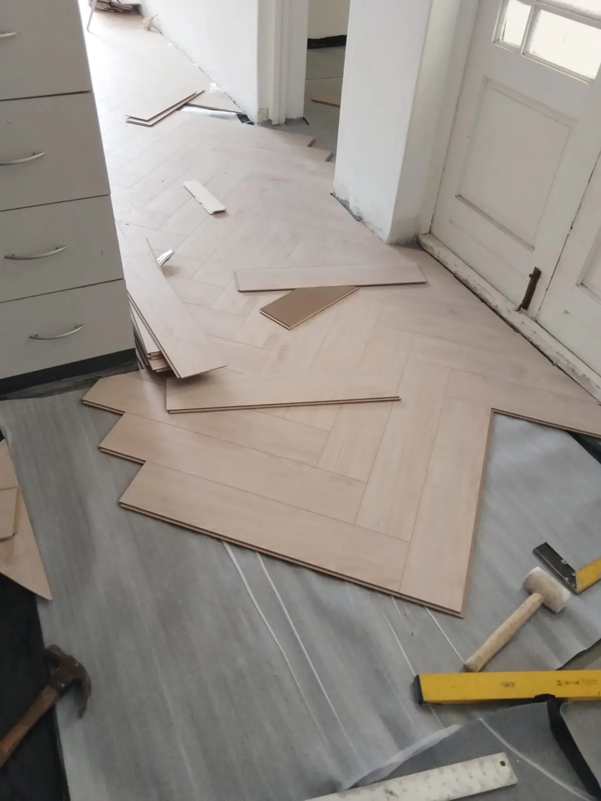 Herringbone floor installation at doorway