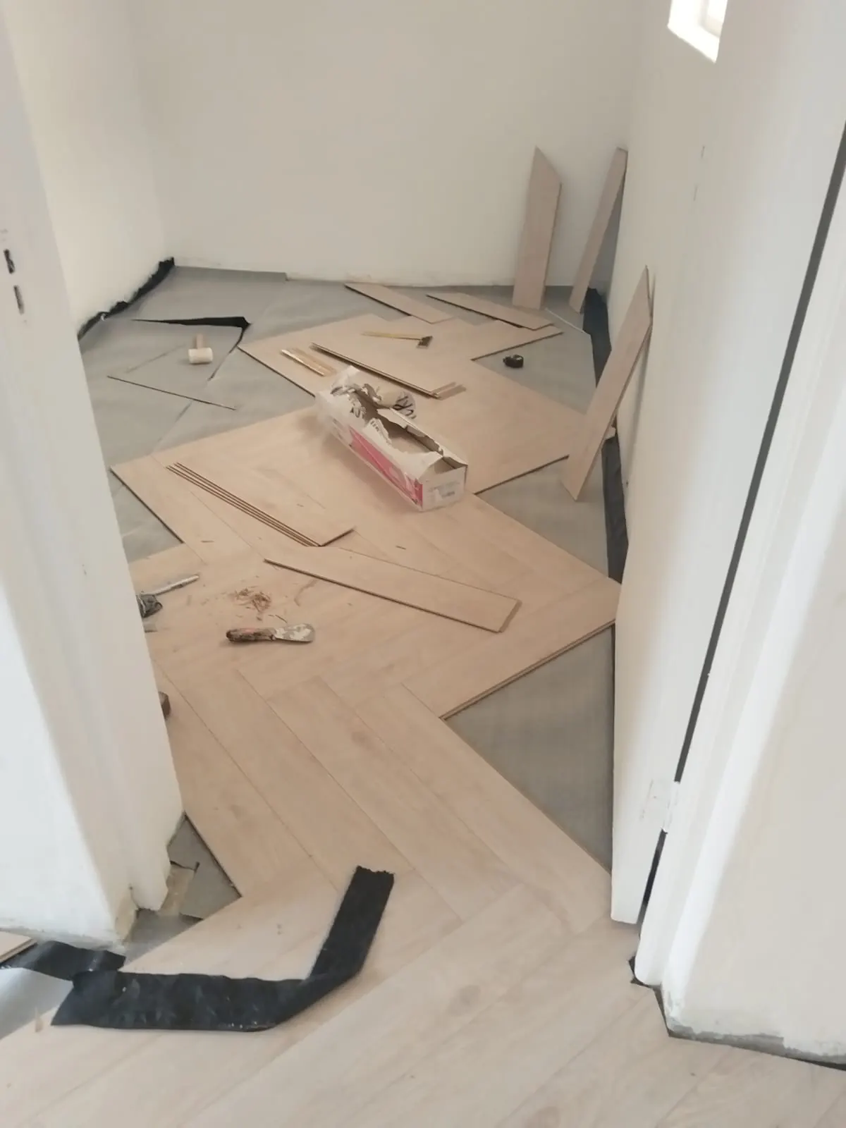 Herringbone floor being fitted in corner room