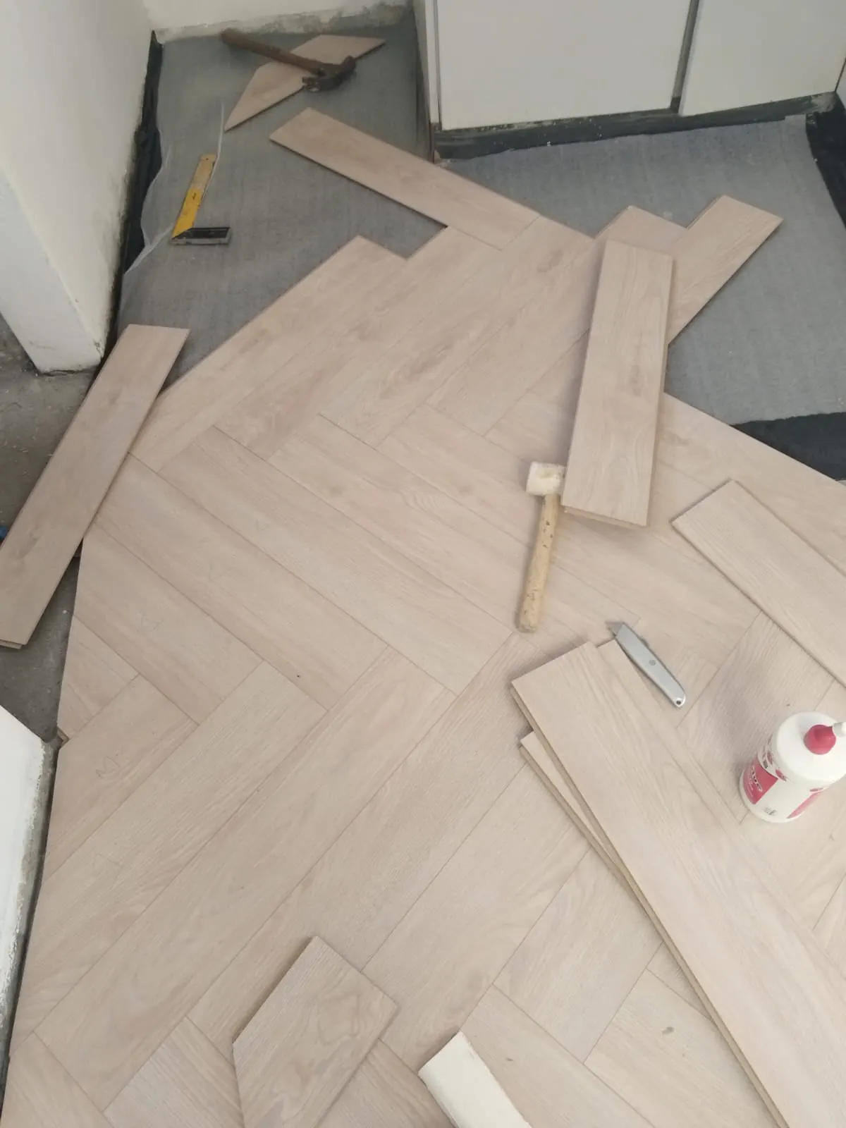 Laying out herringbone floor boards with mallet